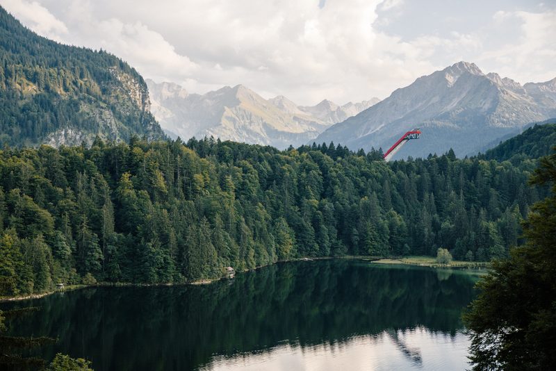 Blick über den Freibergsee bei Oberstdorf auf die Heini-Klopfer-Skiflugschanze, dahinter die Allgäuer Berge